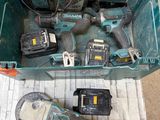 une boîte verte posée par terre, contenant des outils