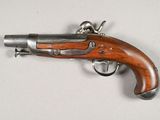 a close up of a gun with a wooden handle on a white surface