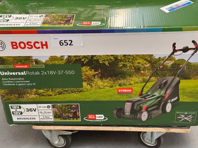 the box of a lawn mower is sitting on top of the cart