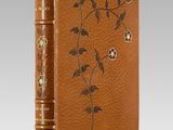 a brown leather book with flowers and leaves on it
