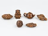 six petites figurines d'animaux en bois posées sur une surface blanche