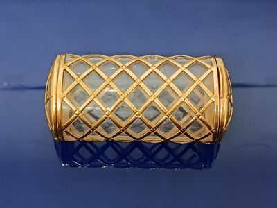 une image montrant un gros plan d'un bracelet en or posé sur une surface bleue