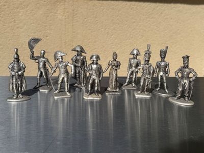 silver figurines of soldiers with spears and shields on a table