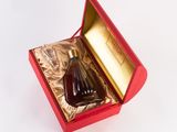 a bottle of liquor in a red box on a white surface