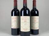 three bottles of red wine sitting next to each other on a table