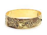 gros plan d'un bracelet en or sur fond blanc