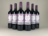 six bottles of wine are lined up on a table