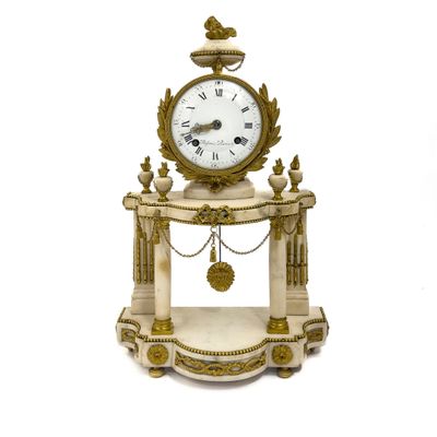 une petite horloge posée sur un socle, entourée d'une chaîne