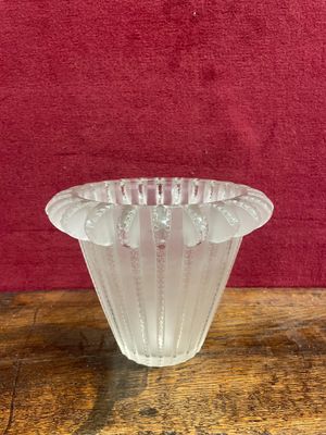 clear glass vase sitting on a wooden table with a red background