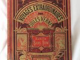 un vieux livre posé sur une surface blanche, avec une couverture rouge