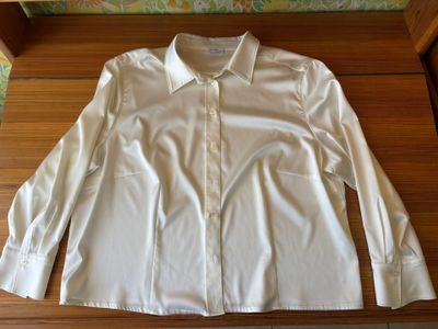 white shirt on a wooden table with a floral wallpaper behind it