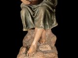 statue of a woman sitting on a rock holding a mandolin
