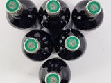 six bottles of wine are arranged in a circle on a white surface