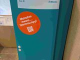 a blue and orange trash can with a sticker on it