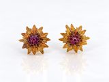 une photo d'une paire de boucles d'oreilles en forme de fleurs, en or et rubis