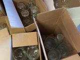 several boxes of empty wine glasses are sitting on the floor
