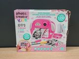 a pink toy camera sitting on top of a wooden table