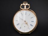 a gold pocket watch with roman numerals on the face