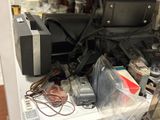 a pile of electronics sitting on a shelf in a room