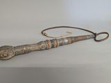 an old wooden stick with a metal handle sitting on a table