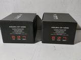 pair of black boxes on a white table with a white background