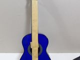 a blue guitar sitting on top of a white table next to a pair of scissors