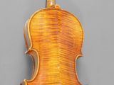 an old violin with a wooden back and bow on a gray background