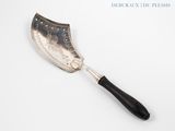 an old silver and black spatula on a white surface