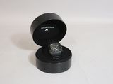 une boîte noire contenant une montre, posée sur une surface blanche