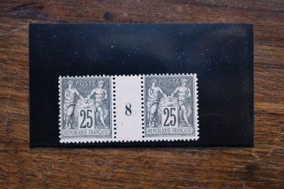 deux timbres sur une enveloppe noire posée sur une table en bois