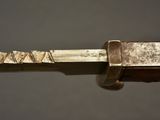 close up of a knife with a wooden handle on a gray surface