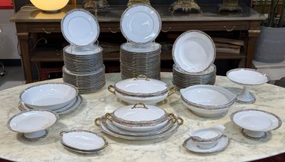 une table sur laquelle se trouvent beaucoup d'assiettes et de bols