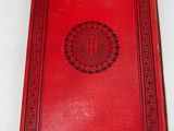 a red book with a medallion on the cover