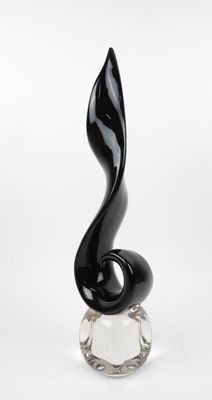 sculpture en verre noir posée sur un socle transparent, sur fond blanc