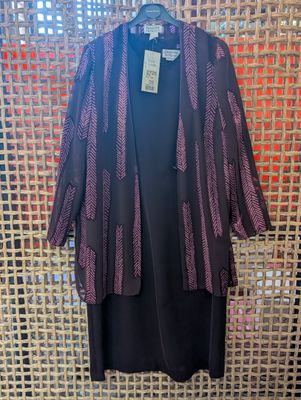 a black dress with a purple and black jacket on a hanger