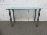 une photo d'une table en verre avec des pieds en métal