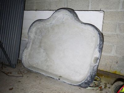 a large cement object sitting on the ground next to a bike