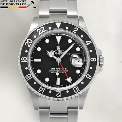 rolex watch with black dial and red hands on a stainless steel bracelet
