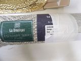 a roll of white yarn on a table next to a box of gold foil