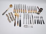 de nombreux types de couteaux et de cuillères sur la table