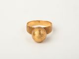 a close up of a gold ring on a white surface
