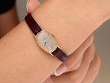 someone is holding a wrist with a watch on it that is on a table