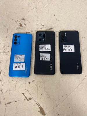 Trois modèles de téléphones Oppo de couleurs différentes sont posés sur une table.