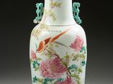 un vase blanc orné d'un oiseau et de fleurs