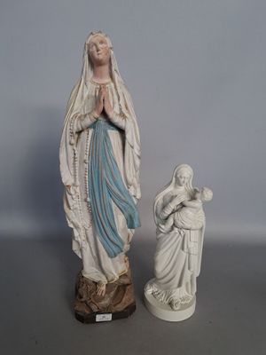 deux statues de la Vierge Marie et de l'Enfant Jésus posées sur une table