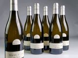 six bottles of wine are lined up in a row on a table