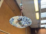 a blue and white bowl hanging from the ceiling