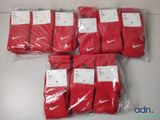 un tas de chaussettes Nike rouges dans des sacs en plastique posés sur une table