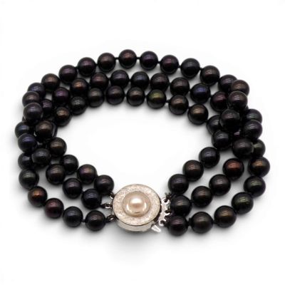 un gros plan sur un bracelet en perles muni d'un fermoir en perle et en argent