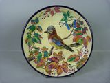 une assiette décorative ornée d'un oiseau, posée sur une table